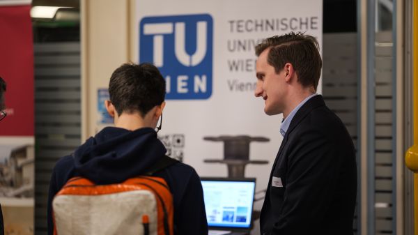 2 Personen vor dem Plakat der TU Wien