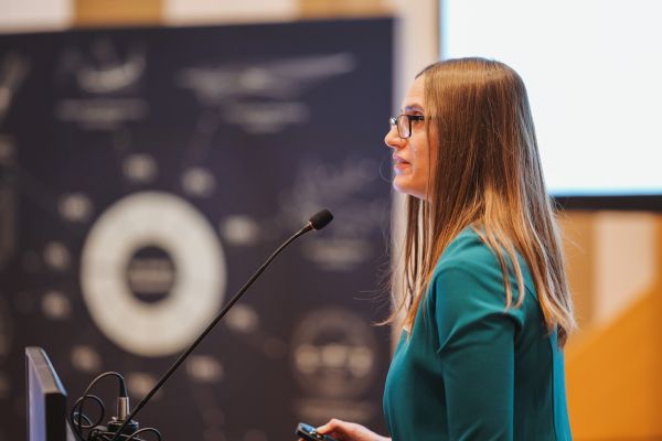 Eine Frau mit langen braunen Haaren redet am Rednerpult.