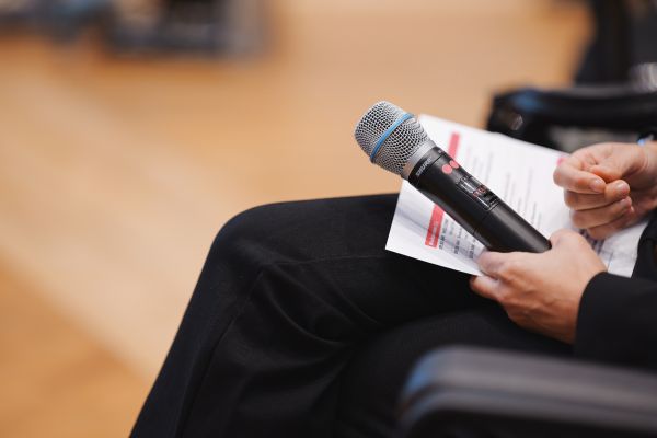 Sitzende Person hält das Microphon.
