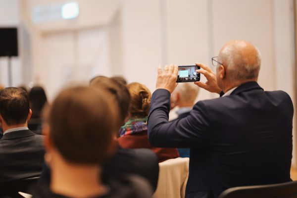 Ein Mann fotografiert mit seinem Handy.