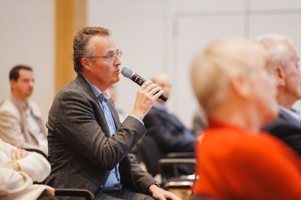 Ein Mann aus dem Publikum spricht ins Microphon.