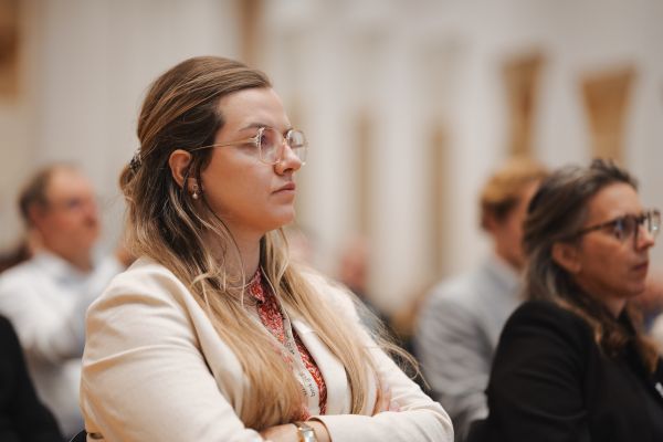 Eine Frau im Publikum hört gespannt zu.